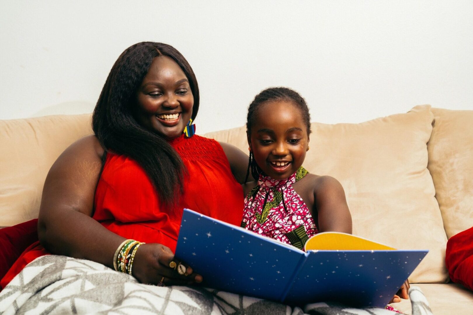 A woman and her daughter are reading together.