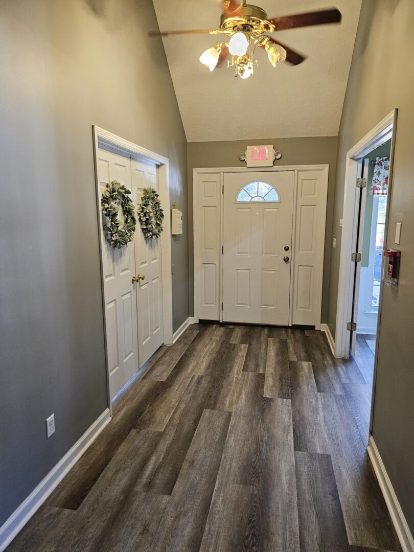 A hallway with two doors and a wooden floor.