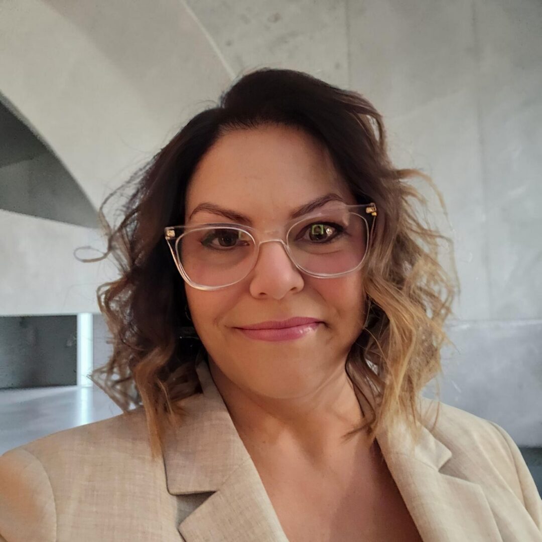 Smiling woman with glasses in beige blazer