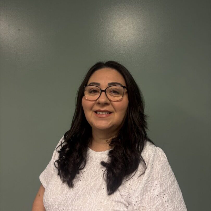 Smiling woman wearing glasses against green background