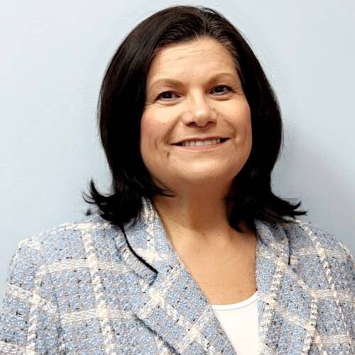 A woman with dark hair and a blue jacket.